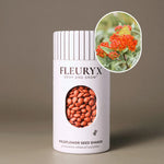 Fleuryx Butterfly Milkweed (Asclepias tuberosa) Native Wildflower Seeds in a white seed shaker with a striped lid, showing orange seed pellets from its colorful coated wildflower seeds and a photo of Butterfly Milkweed flowers.