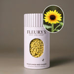 Fleuryx Common Sunflower (Helianthus annuus) Native Wildflower Seeds in a white seed shaker with a striped lid, showing yellow colorful coated wildflower seeds and a photo of Common Sunflower flowers.