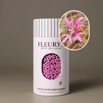 Fleuryx Deerhorn Clarkia (Clarkia pulchella) Native Wildflower Seeds in a white seed shaker with a striped lid, showing pink colorful coated wildflower seeds and a photo of Deerhorn Clarkia flowers.