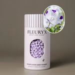 Fleuryx Five Spot (Nemophila maculata) Native Wildflower Seeds in a white seed shaker with a striped lid, showing white and purple colorful coated wildflower seeds and a photo of Five Spot flowers.