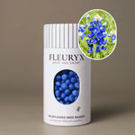 Fleuryx Texas Bluebonnet (Lupinus texensis) Native Wildflower Seeds in a white seed shaker with a striped lid, showing blue colorful coated wildflower seeds and a photo of Texas Bluebonnet flowers.